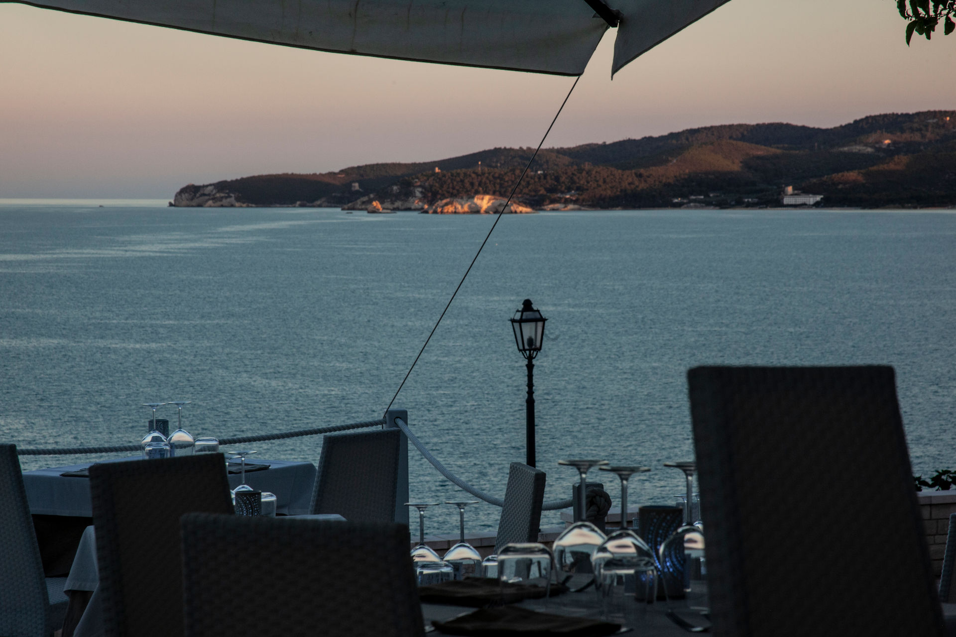 tavoli apparecchiati al tramonto vista mare del ristorante pesce fresco piazzetta Petrone a Vieste