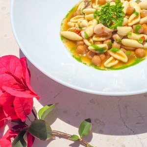 Primo piatto di mare con vino rosato e vista panoramica su Vieste
