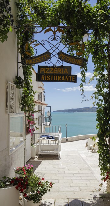 esterno con tavoli di legno del ristorante di pesce fresco centro storico di Vieste in piazzetta Petrone