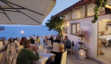 esterno con tavoli di legno del ristorante di pesce fresco centro storico di Vieste in piazzetta Petrone