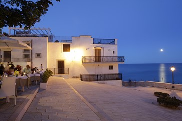 esterno con tavoli di legno del ristorante di pesce fresco centro storico di Vieste in piazzetta Petrone