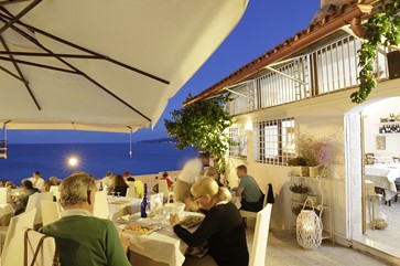 esterno con tavoli di legno del ristorante di pesce fresco centro storico di Vieste in piazzetta Petrone